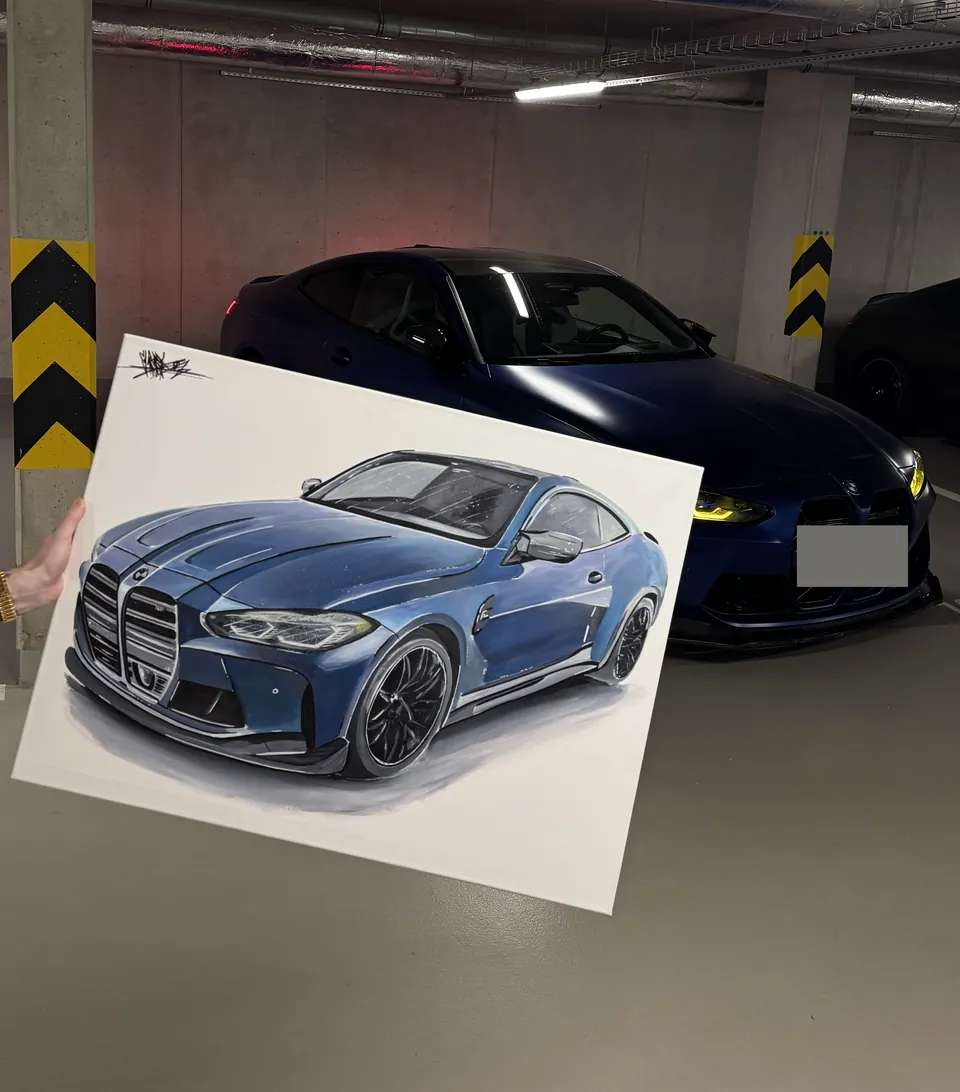Obraz modrého BMW M4 držený před skutečným vozem v garáži