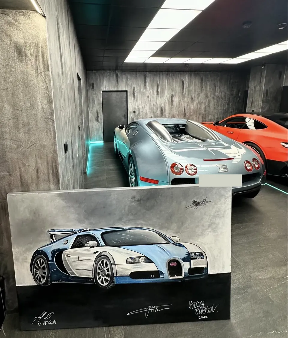 Velké plátno s Bugatti Veyron, za ním skutečný vůz v garáži